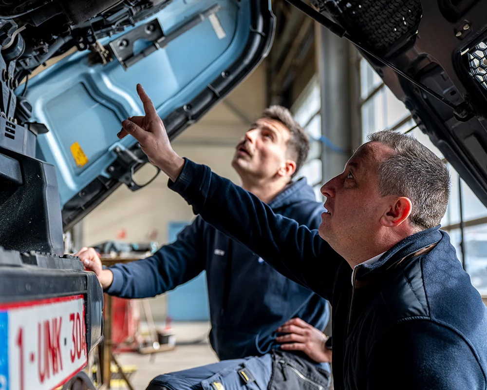 Deux hommes regardant le moteur d'un camion